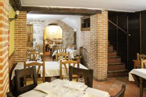 塞哥维亚圣米格尔酒店的一间带桌椅的餐厅以及砖墙