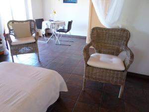 蓬塔戈尔达Casa Bellavista的一间设有两把椅子、一张桌子和一张床的房间