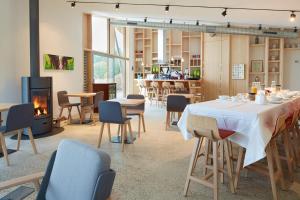 SaubionLes Échasses Golf & Surf Eco Lodge的一间带桌椅和壁炉的用餐室