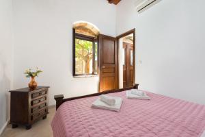 拉多斯Villa Claudia in Lardos的一间卧室配有一张床、一个梳妆台和一扇窗户。