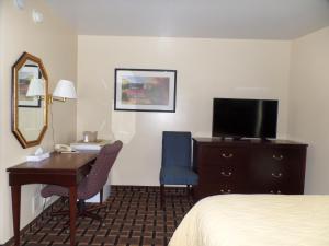 奇利科西Executive Inn Chillicothe的酒店客房配有书桌、床和镜子