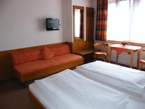 罗滕堡霍夫曼施默泽膳食公寓酒店的酒店客房设有两张床、一张沙发和一张桌子。