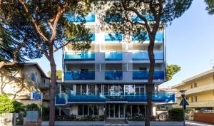 里乔内渴望酒店的公寓大楼设有蓝色的阳台和树木