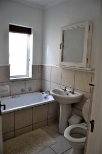 普利登堡湾31 Riverclub Villas的带浴缸、盥洗盆和卫生间的浴室