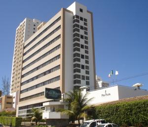 萨尔瓦多比萨广场酒店 的一座大型建筑,前面有汽车停放