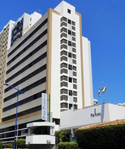 萨尔瓦多比萨广场酒店 的前面有标志的高大的白色建筑
