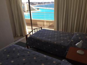 阿尔加罗沃Apartamento en San Alfonso del Mar 3D-2B的酒店客房设有两张床和大窗户。