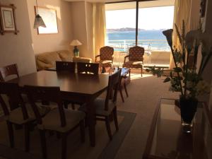 阿尔加罗沃Apartamento en San Alfonso del Mar 3D-2B的客厅配有桌椅,享有海景