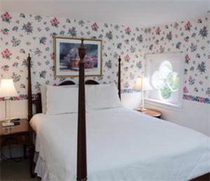 埃德加敦阿什利旅馆的一间卧室配有白色床单和鲜花。