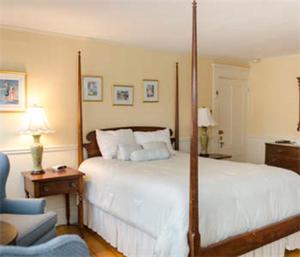 埃德加敦阿什利旅馆的一间卧室配有一张大床和一张蓝色椅子