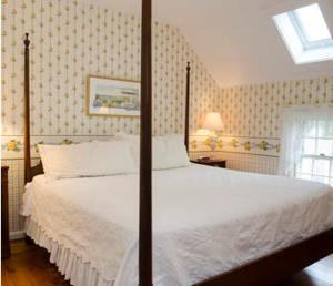 埃德加敦阿什利旅馆的一间卧室配有一张带白色床单的床和一扇窗户。