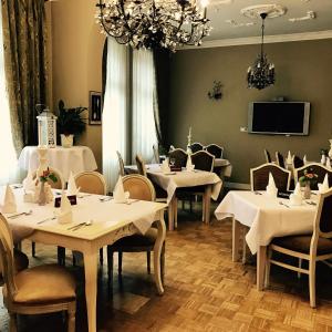 库多瓦-兹德鲁伊阿玛利亚酒店的一间配备有白色桌椅和电视的用餐室