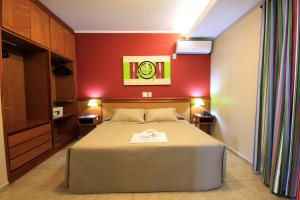 奥林匹亚Thermas Park Resort & SPA by Hot Beach的一间卧室设有一张床和红色的墙壁