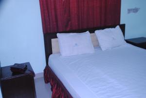 库克斯巴扎Shopno Bilash Holiday Suites的卧室配有白色的床和红色窗帘