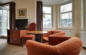 什平德莱鲁夫姆林Pension Villa Miluška的客厅配有椅子、桌子和电视