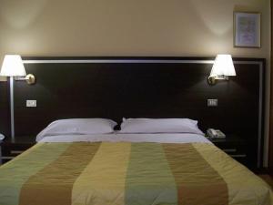 雷焦艾米利亚拉罗斯塔酒店的一间卧室配有一张大床和两盏灯