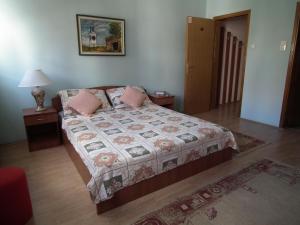 诺维萨德娜莎提维达瓦宾馆的一间卧室配有床、两张桌子和一盏灯。