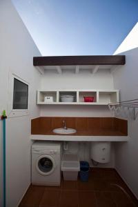 普拉亚布兰卡贝妮塔别墅酒店的小型浴室设有洗衣机和水槽。