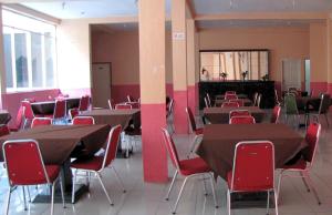 邦加槟港米特拉花园酒店 的大楼内带桌椅的房间
