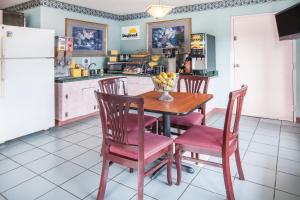 芒廷维尤芒廷维尤戴斯汽车旅馆的一间带桌椅的厨房和一间带冰箱的厨房