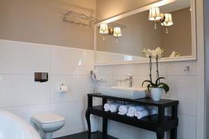 斯拉百斯卡西诺别墅酒店的一间带水槽、卫生间和镜子的浴室