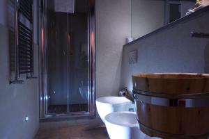 蒙特里久尼黎莱斯卡斯特比哥西酒店的浴室设有大型木制浴缸,位于厕所旁边