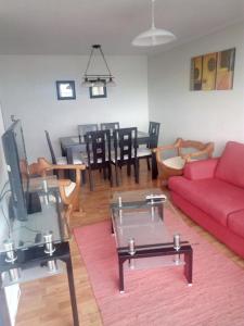 比亚里卡Villarrica Mirador Apartment的客厅配有红色的沙发和桌子