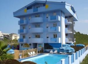 朱利亚诺瓦蓝色海洋公寓式酒店的一座带游泳池的大楼,毗邻一个度假胜地