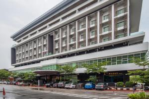 马六甲马尔维鲁斯酒店的一座大型建筑,前面有汽车停放