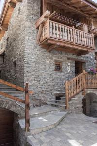奥斯塔Vecchio Fienile的一座石头建筑,设有楼梯和阳台