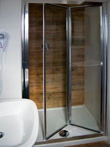 菲乌米奇诺睡觉旅行酒店的浴室里设有玻璃门淋浴