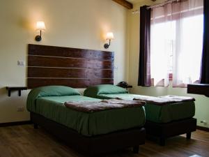 菲乌米奇诺睡觉旅行酒店的一间卧室配有两张带绿床单和床头板的床。