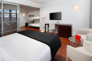 塞尔勒HG策尔勒公寓酒店的一间卧室配有一张床、一张桌子和一台电视。