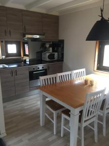 恩厄尔霍尔姆Klitterbyn Lodge的厨房配有木桌和白色椅子