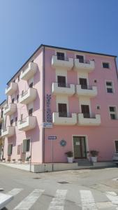 圣特雷莎加卢拉斯卡诺舒适酒店的街道边的粉红色建筑