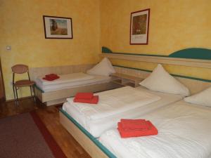 克拉根福Gasthof Schlosswirt的宿舍间内的两张床,上面有红色毛巾