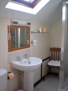 科尼斯顿黑公牛酒店的一间带水槽、镜子和椅子的浴室