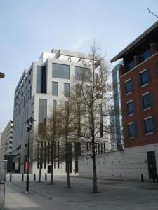 利物浦Merchant Quarters Apartments的一座高大的白色建筑,前面有树木