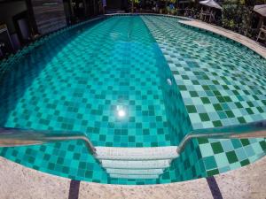 伊塔卡雷特拉宝儿精品酒店的游泳池铺有绿色和白色的瓷砖地板。