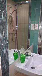 格但斯克Forsycja的浴室设有水槽,上面有两杯绿茶