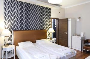 布达佩斯八角形房舍酒店的一间卧室设有一张大床和黑白墙