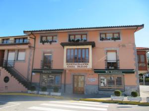 GibajaCasa Pardo的粉红色的建筑,设有窗户和街道