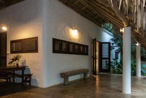 拉斯加勒拉斯La Cueva Eco-Lodge的白色的建筑,配有长凳和桌子