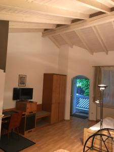 GeiselhöringHotel Korfu的客厅设有木制天花板、书桌和门