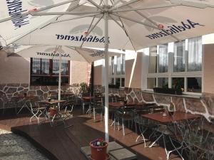 GeiselhöringHotel Korfu的餐厅配有桌椅,位于伞下