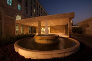 科纳克里卡马耶尼帕尔姆酒店的一座大型喷泉,在晚上在一座建筑前