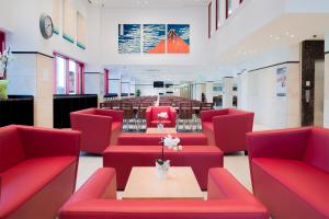 美因河畔法兰克福东横INN美因河畔法兰克福火车总站酒店的一间设有红色椅子和桌子的等候室
