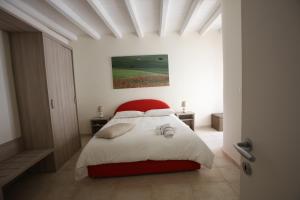 鲁沃迪普利亚B&B Casa Rubis的卧室配有红色和白色的床和绘画作品