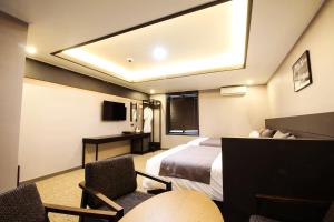 釜山釜山B.Cent酒店的配有一张床和一张书桌的酒店客房