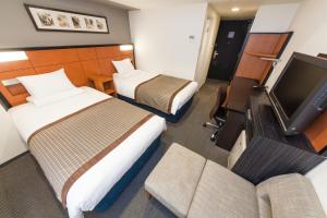 大阪MYSTAYS 堺筋本町酒店的酒店客房设有两张床和一台平面电视。